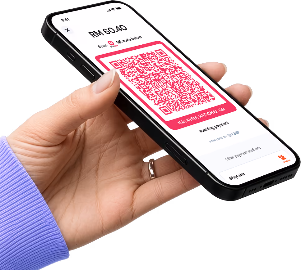 A hand holding a phone showing DuitNow QR screen on CHIP mini app waiting for customer to scan and pay